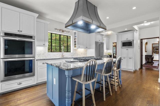20 Cook Rd, Stamford, CT 06902 - kitchen featuring appliances with stainless steel finishes, island exhaust hood, a sink, white cabinetry, and recessed lighting