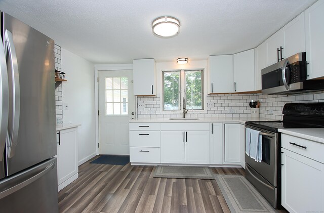 537 Hobart St, Southington, CT 06489 - kitchen featuring stainless steel appliances, a sink, light countertops, dark wood-type flooring, and backsplash