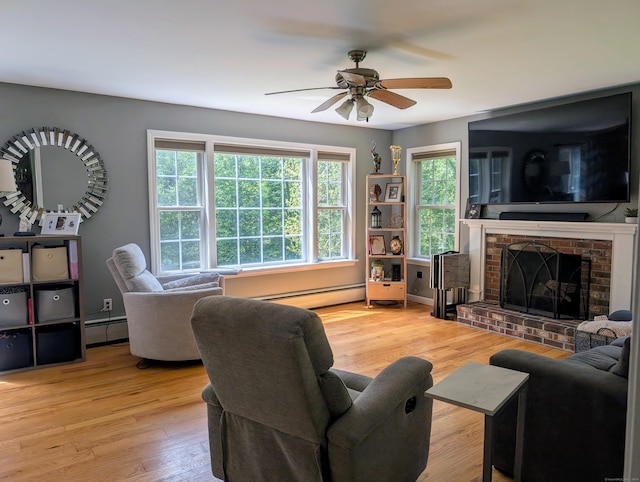 35 Snake Meadow Rd, Killingly, CT 06239 - living room with a baseboard radiator, wood finished floors, a ceiling fan, and a brick fireplace