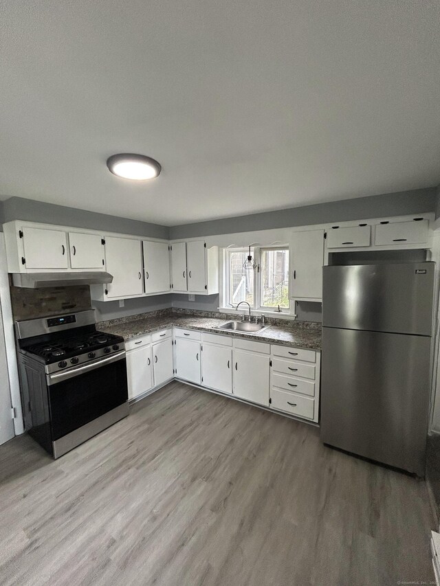 51 Division St, Norwich, CT 06360 - kitchen featuring appliances with stainless steel finishes, light wood finished floors, white cabinets, and under cabinet range hood