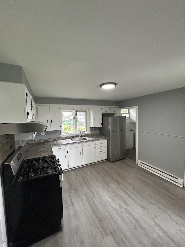 51 Division St, Norwich, CT 06360 - kitchen featuring stainless steel appliances, a baseboard heating unit, range hood, light wood finished floors, and white cabinetry