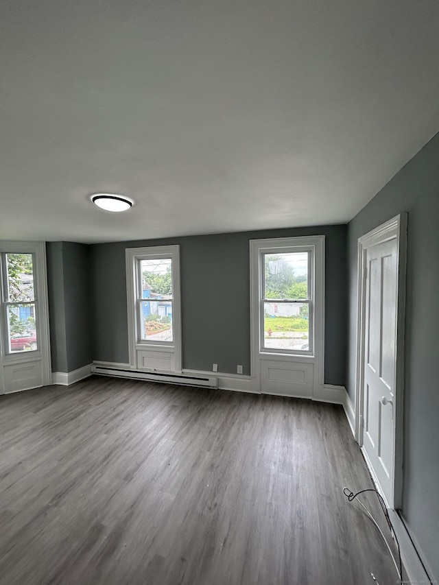 51 Division St, Norwich, CT 06360 - unfurnished room featuring a baseboard radiator, dark wood finished floors, and plenty of natural light