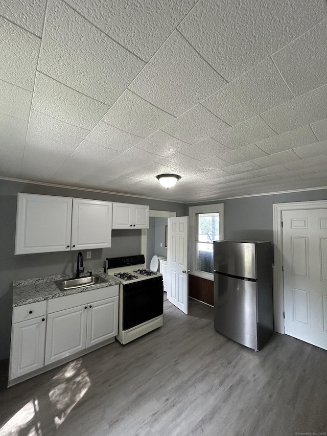 51 Division St, Norwich, CT 06360 - kitchen with freestanding refrigerator, range with gas cooktop, white cabinets, light wood finished floors, and light countertops