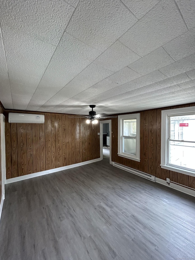 51 Division St, Norwich, CT 06360 - unfurnished living room with wood finished floors, a wall mounted AC, wood walls, ceiling fan, and a baseboard heating unit