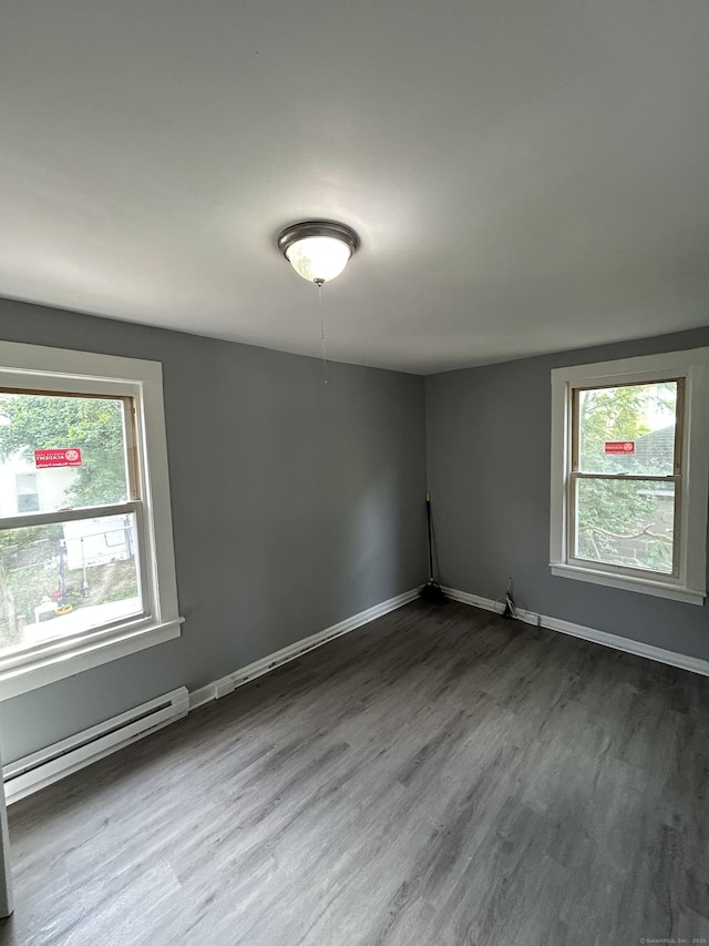 51 Division St, Norwich, CT 06360 - empty room featuring a baseboard heating unit, plenty of natural light, and dark wood finished floors