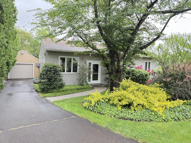 17 Edgecomb St, Hamden, CT 06517 - view of property hidden behind natural elements with an outdoor structure, a detached garage, driveway, and roof with shingles