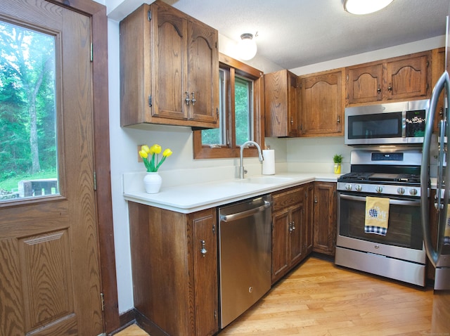115B Torrington Ave, Canton, CT 06019 - kitchen featuring stainless steel appliances, a sink, light countertops, light wood-style floors, and brown cabinetry