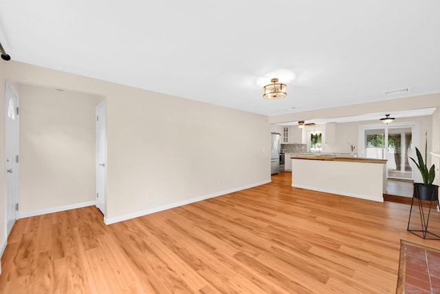 21 Enfield St, Windsor Locks, CT 06096 - unfurnished living room with light wood-style flooring, a ceiling fan, and baseboards