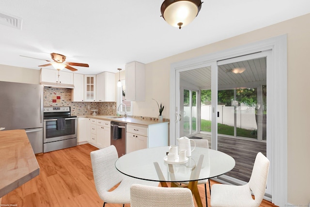 21 Enfield St, Windsor Locks, CT 06096 - kitchen with stainless steel appliances, a sink, light wood-style flooring, a ceiling fan, and decorative backsplash