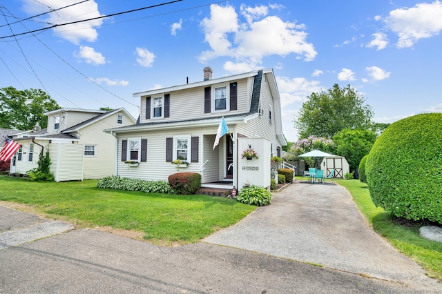 7 Meriden Ave, Westbrook, CT 06498 - view of front of property with covered porch, a front lawn, a chimney, asphalt driveway, and a gambrel roof