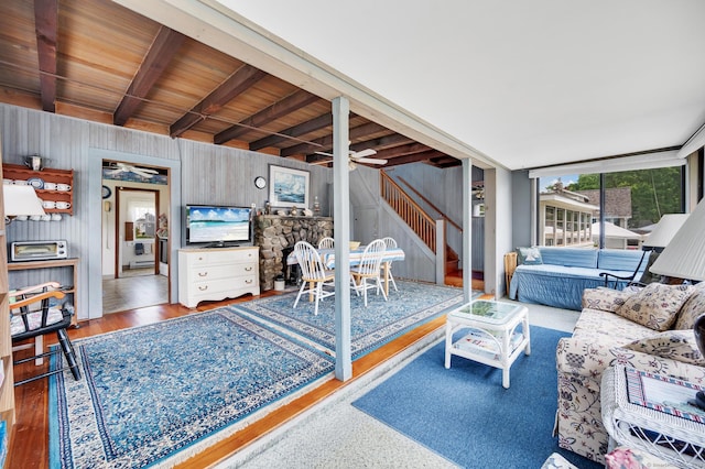 7 Meriden Ave, Westbrook, CT 06498 - living room with ceiling fan, wood walls, stairs, wood finished floors, and beam ceiling