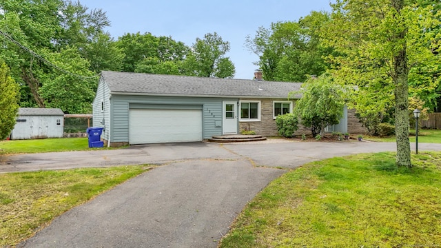 1704 Hill St, Suffield, CT 06078 - view of front of house featuring a garage, asphalt driveway, a front yard, and a chimney