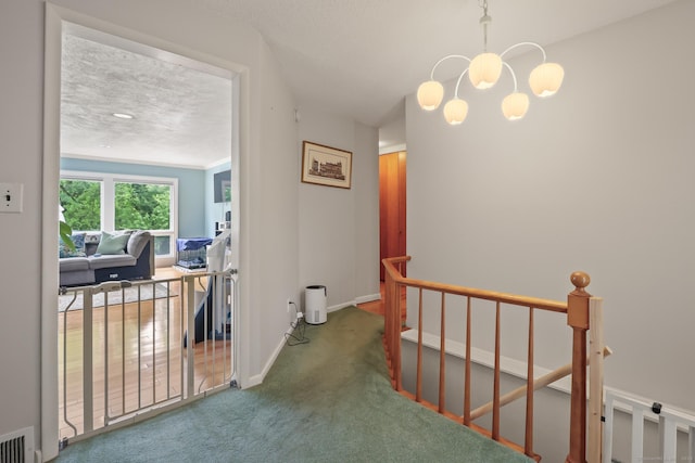 1704 Hill St, Suffield, CT 06078 - hall featuring an upstairs landing, a chandelier, carpet, and a textured ceiling