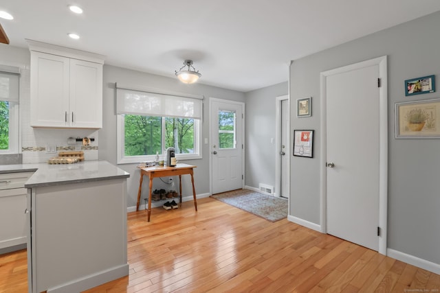 1704 Hill St, Suffield, CT 06078 - kitchen with light wood-style floors, white cabinetry, recessed lighting, tasteful backsplash, and light stone countertops