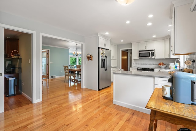 1704 Hill St, Suffield, CT 06078 - kitchen featuring stainless steel appliances, recessed lighting, a chandelier, white cabinetry, and light countertops