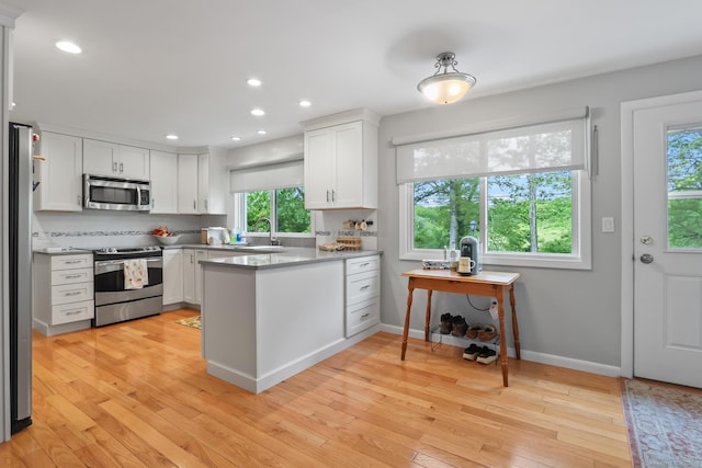 1704 Hill St, Suffield, CT 06078 - kitchen with stainless steel appliances, a peninsula, white cabinetry, light wood finished floors, and recessed lighting