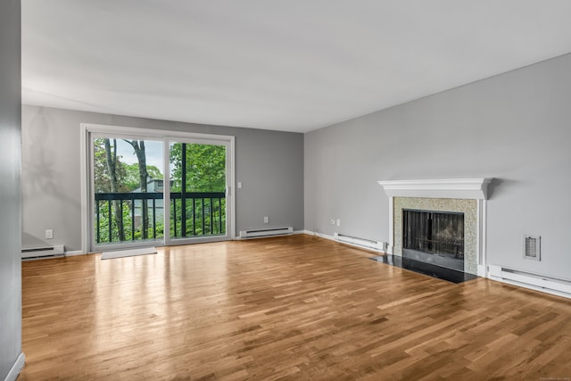 19 Harbour Vlg Unit B, Branford, CT 06405 - unfurnished living room with baseboard heating, a fireplace with flush hearth, and wood finished floors