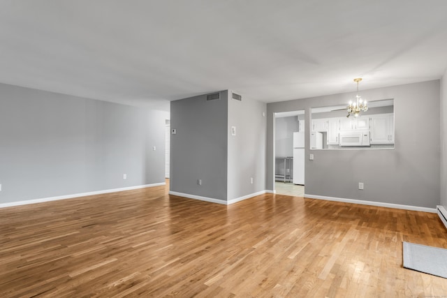 19 Harbour Vlg Unit B, Branford, CT 06405 - unfurnished living room with a chandelier, light wood-type flooring, and baseboards