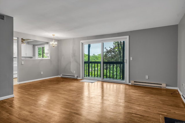 19 Harbour Vlg Unit B, Branford, CT 06405 - empty room featuring a baseboard heating unit, a chandelier, and plenty of natural light