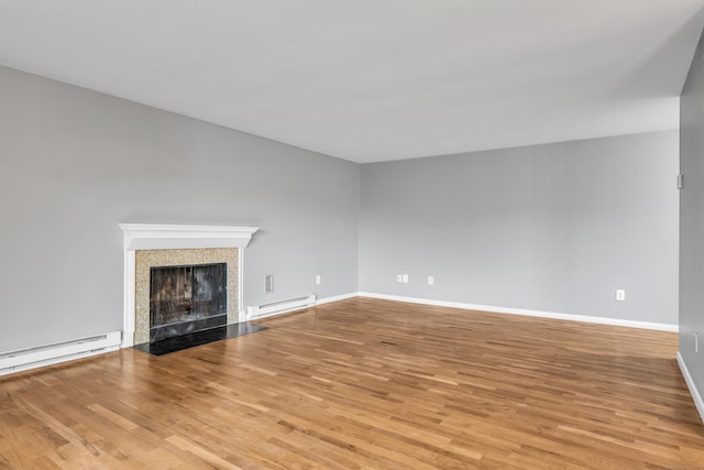 19 Harbour Vlg Unit B, Branford, CT 06405 - unfurnished living room with a baseboard heating unit, light wood-style floors, a tiled fireplace, and baseboards