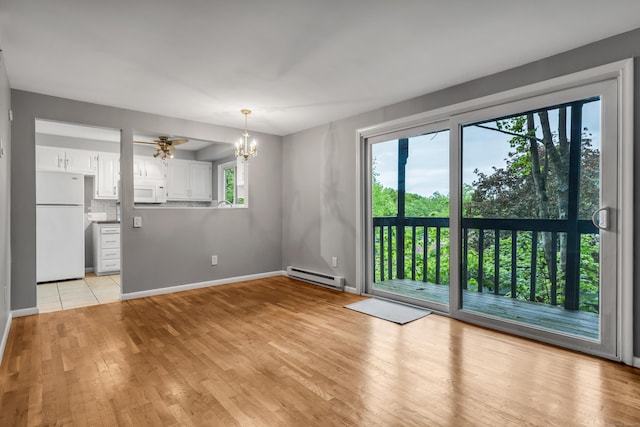 19 Harbour Vlg Unit B, Branford, CT 06405 - unfurnished living room featuring baseboard heating, a chandelier, light wood-style flooring, and baseboards