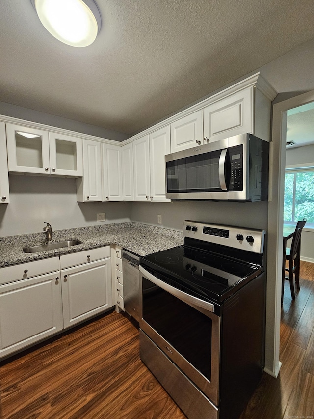 42 Village Rd Unit 42, Southington, CT 06489 - kitchen with appliances with stainless steel finishes, a sink, dark wood finished floors, white cabinetry, and glass insert cabinets