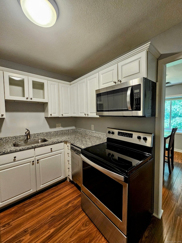 42 Village Rd Unit 42, Southington, CT 06489 - kitchen featuring appliances with stainless steel finishes, a sink, dark wood-type flooring, white cabinetry, and a textured ceiling
