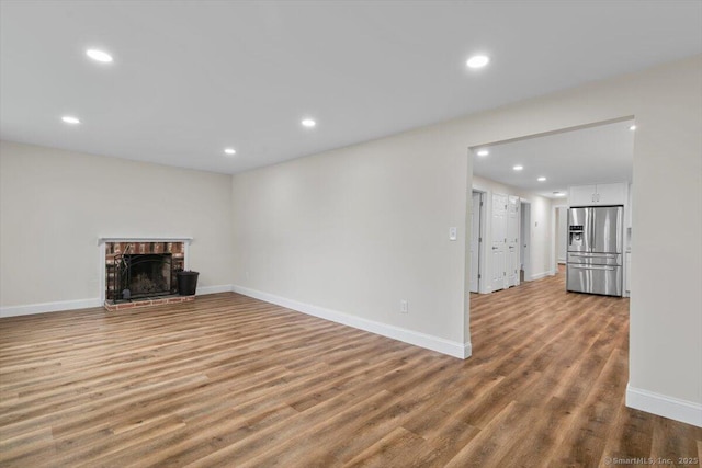 121 Lurton St, New Britain, CT 06053 - unfurnished living room with wood finished floors, recessed lighting, baseboards, and a brick fireplace
