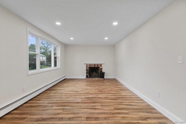 121 Lurton St, New Britain, CT 06053 - unfurnished living room with baseboard heating, recessed lighting, wood finished floors, baseboards, and a brick fireplace