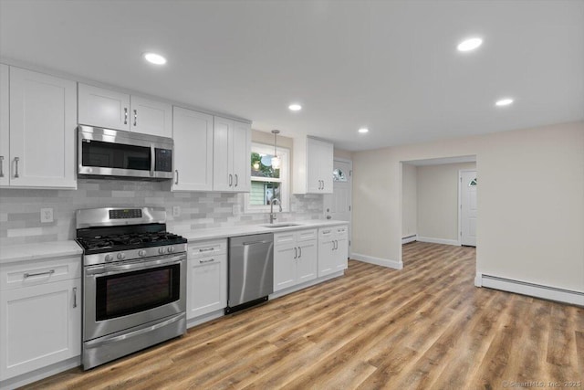 121 Lurton St, New Britain, CT 06053 - kitchen featuring stainless steel appliances, a sink, a baseboard heating unit, light countertops, and decorative backsplash