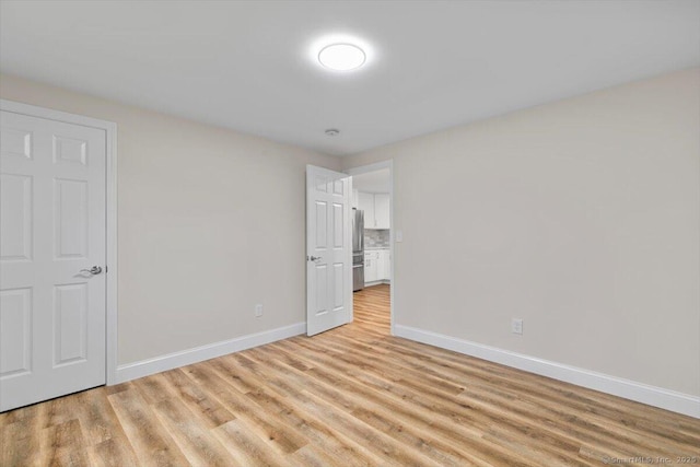 121 Lurton St, New Britain, CT 06053 - unfurnished bedroom featuring freestanding refrigerator, baseboards, and light wood-style flooring