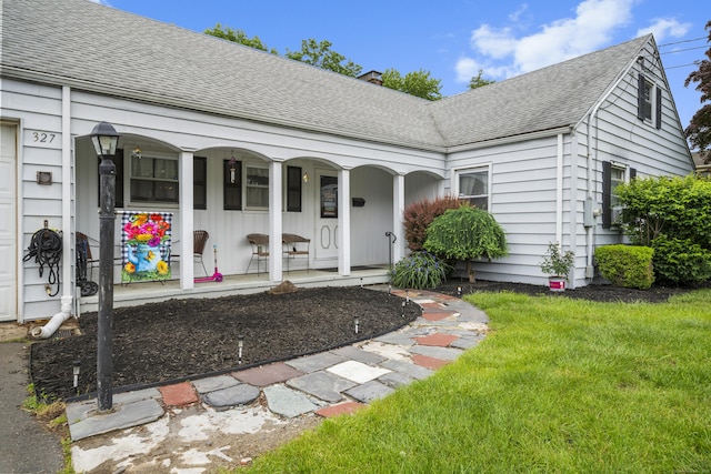 327 Steele St, New Britain, CT 06052 - doorway to property with a porch, roof with shingles, and a yard