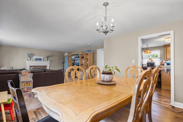 327 Steele St, New Britain, CT 06052 - dining area with a chandelier, wood finished floors, and a fireplace