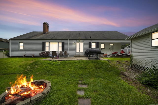 327 Steele St, New Britain, CT 06052 - back of property with an outdoor fire pit, a chimney, a lawn, and a patio