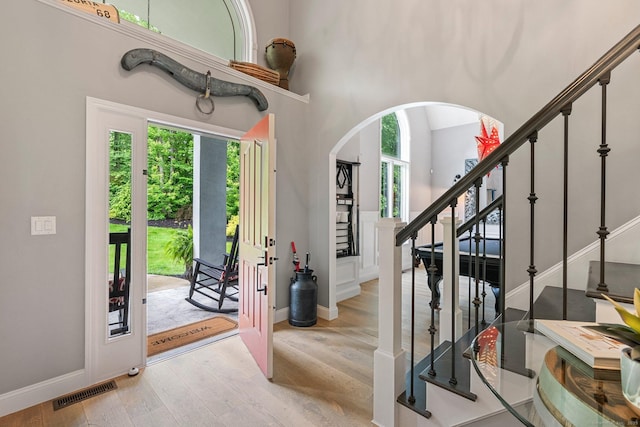 86 Charolais Way, Burlington, CT 06013 - entrance foyer with wood finished floors, stairway, a towering ceiling, arched walkways, and baseboards
