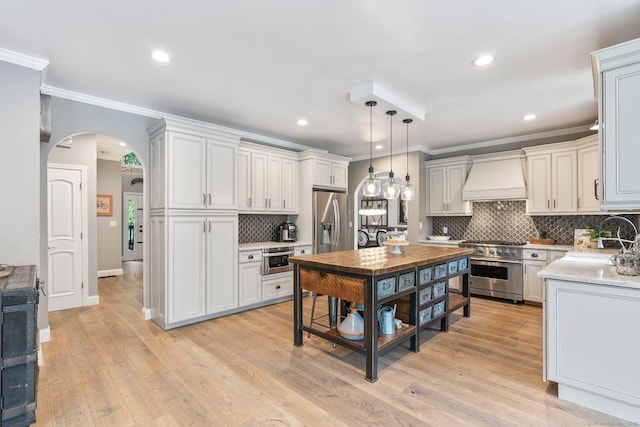 86 Charolais Way, Burlington, CT 06013 - kitchen featuring appliances with stainless steel finishes, premium range hood, ornamental molding, decorative backsplash, and arched walkways
