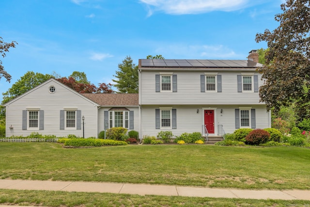 36 Holly Ln, Middletown, CT 06457 - colonial-style house featuring solar panels, a chimney, and a front yard