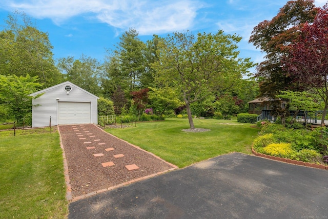 36 Holly Ln, Middletown, CT 06457 - view of green lawn featuring a detached garage, an outdoor structure, driveway, and view of wooded area