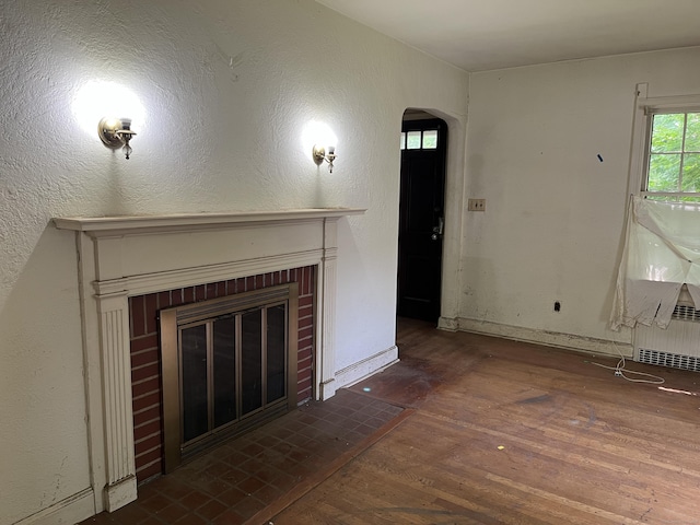 63 Park Rd, Hamden, CT 06517 - unfurnished living room featuring arched walkways, a brick fireplace, and wood finished floors