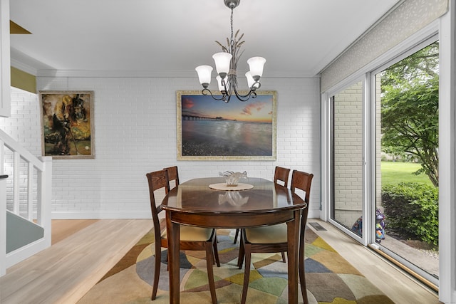 85 Viscount Dr Unit 15C, Milford, CT 06460 - dining area with ornamental molding, wood finished floors, a chandelier, baseboards, and brick wall