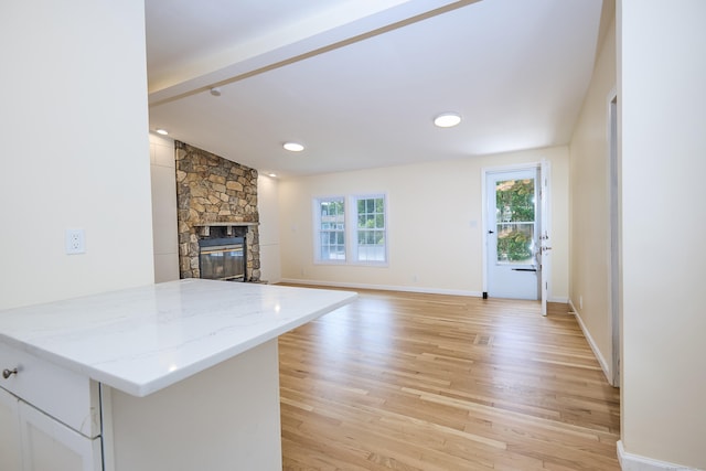 10 Crescent Park Rd, Westport, CT 06880 - unfurnished living room featuring light wood-type flooring, a stone fireplace, beam ceiling, and recessed lighting