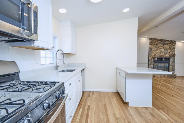 10 Crescent Park Rd, Westport, CT 06880 - kitchen featuring appliances with stainless steel finishes, a peninsula, light countertops, and light wood-type flooring