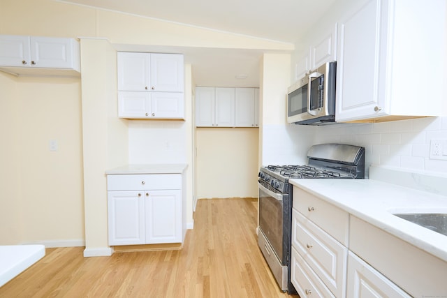 10 Crescent Park Rd, Westport, CT 06880 - kitchen with stainless steel appliances, light wood finished floors, tasteful backsplash, and white cabinetry