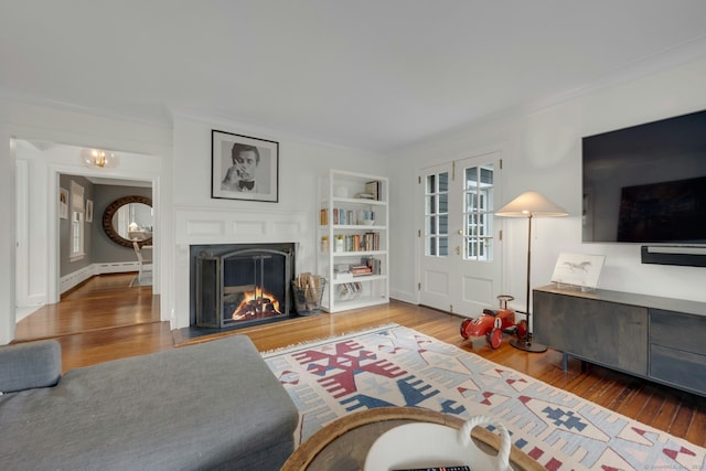 6 Prescott Ln, Greenwich, CT 06830 - living room with wood finished floors, a warm lit fireplace, ornamental molding, a baseboard radiator, and built in features