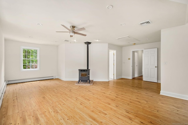 22 Loomis Dr, Coventry, CT 06238 - unfurnished living room with light wood finished floors, a baseboard radiator, a wood stove, baseboards, and a ceiling fan
