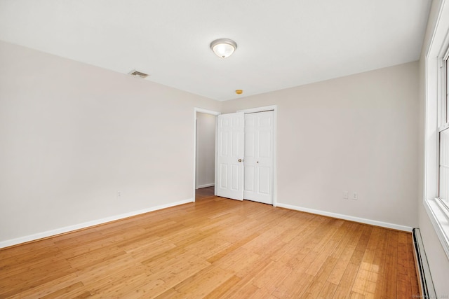 22 Loomis Dr, Coventry, CT 06238 - unfurnished bedroom featuring a baseboard radiator, baseboards, light wood-style floors, and a closet