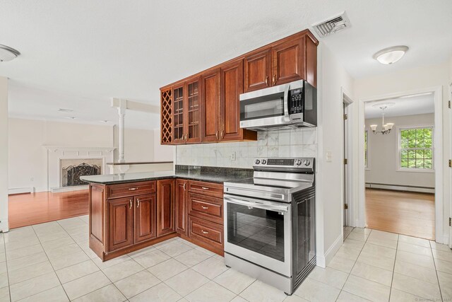 22 Loomis Dr, Coventry, CT 06238 - kitchen with appliances with stainless steel finishes, baseboard heating, dark countertops, a chandelier, and light tile patterned flooring
