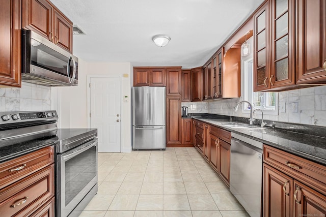 22 Loomis Dr, Coventry, CT 06238 - kitchen with stainless steel appliances, tasteful backsplash, a sink, dark stone counters, and glass insert cabinets
