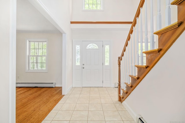 22 Loomis Dr, Coventry, CT 06238 - foyer with a baseboard radiator, stairs, ornamental molding, light wood-style floors, and a high ceiling