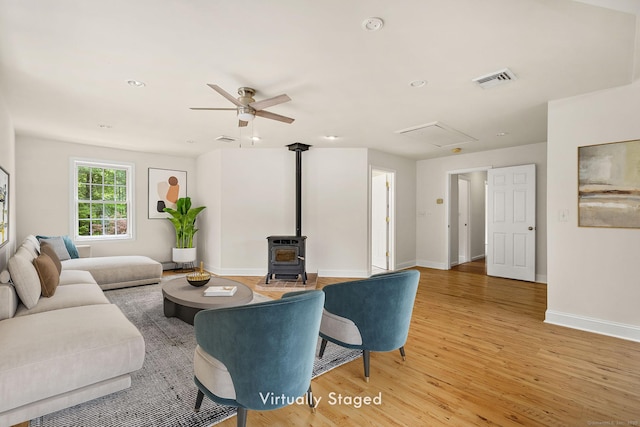 22 Loomis Dr, Coventry, CT 06238 - living room featuring a wood stove, light wood-type flooring, attic access, baseboards, and ceiling fan